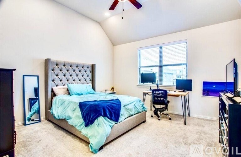 A bedroom with a large bed and a desk with a computer.