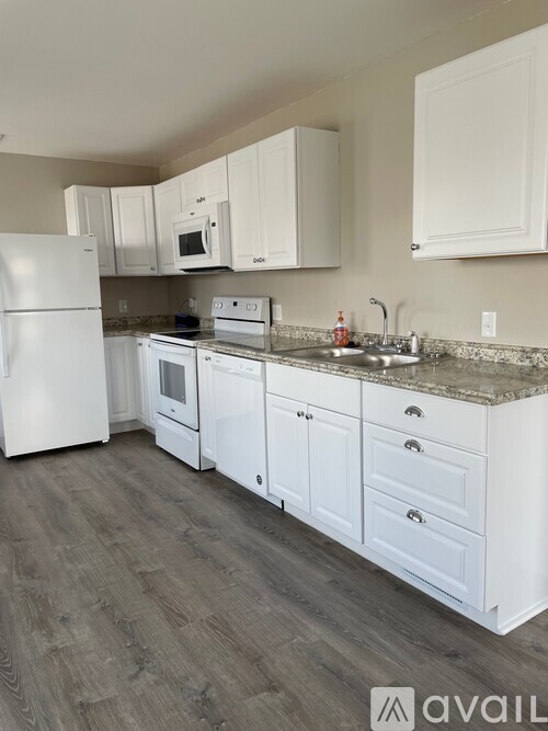 A kitchen with white appliances and cabinets.