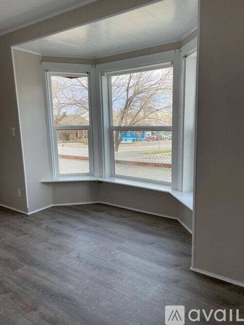 A room with a large window and a grey floor.