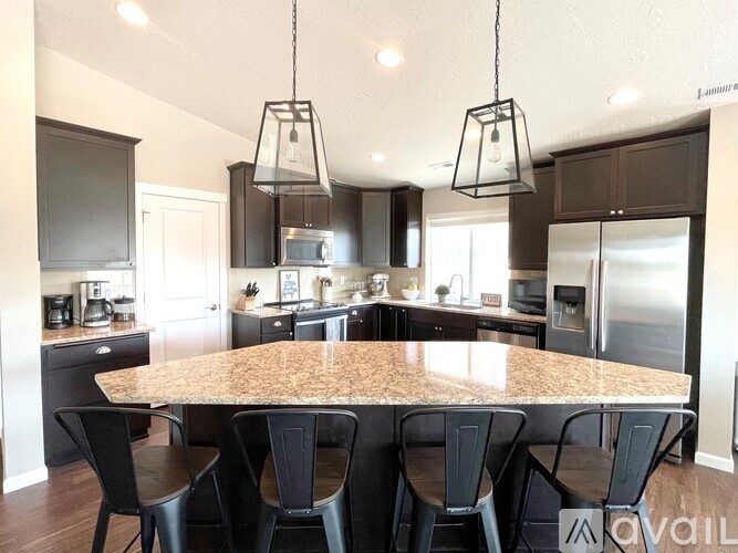 A kitchen with a table and chairs in the foreground and a refrigerator in the background.