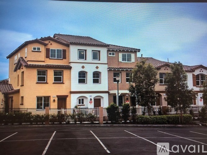 A row of houses with a parking lot in front.