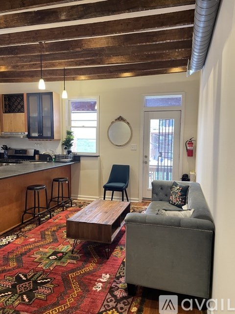 A living room with a grey couch and a wooden coffee table.