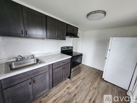 A kitchen with dark wood cabinets and a white fridge.