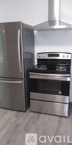 A modern kitchen with a stainless steel refrigerator and oven.