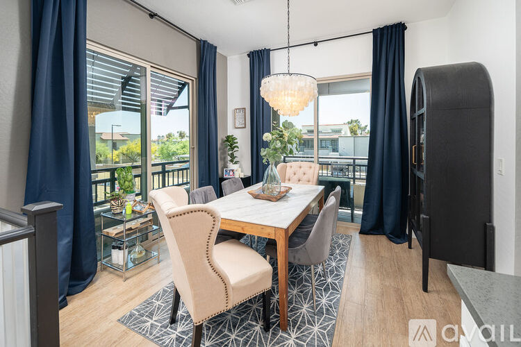 A dining room with a table set for four and a view of the backyard.