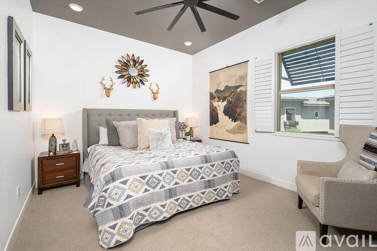 A bedroom with a large bed and a ceiling fan.