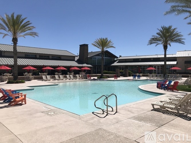 A large swimming pool surrounded by lounge chairs and umbrellas.