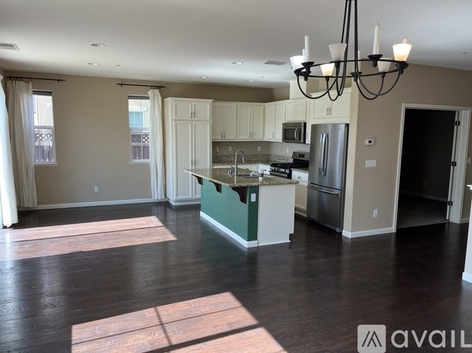 A kitchen with a green island and white cabinets.