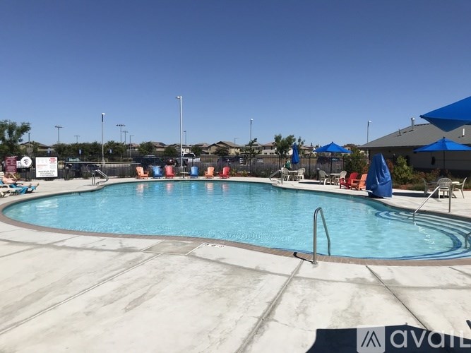 A large outdoor swimming pool with a blue sky in the background.