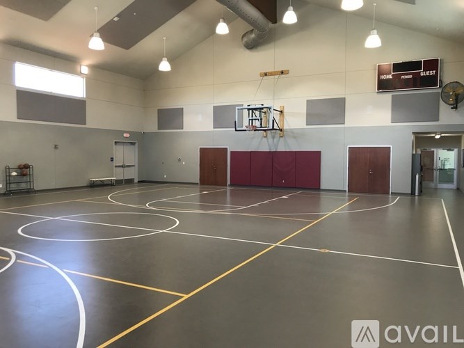 A gym with a basketball court and a sign that says "GUEST".