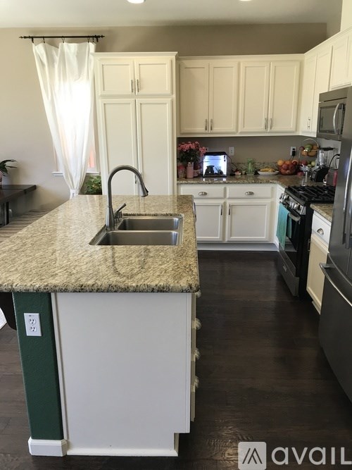 A kitchen with a granite countertop and white cabinets.