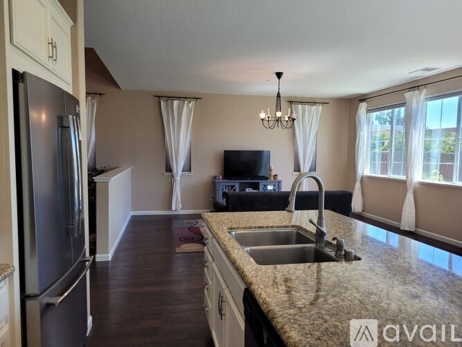 A kitchen with granite countertops and a refrigerator.