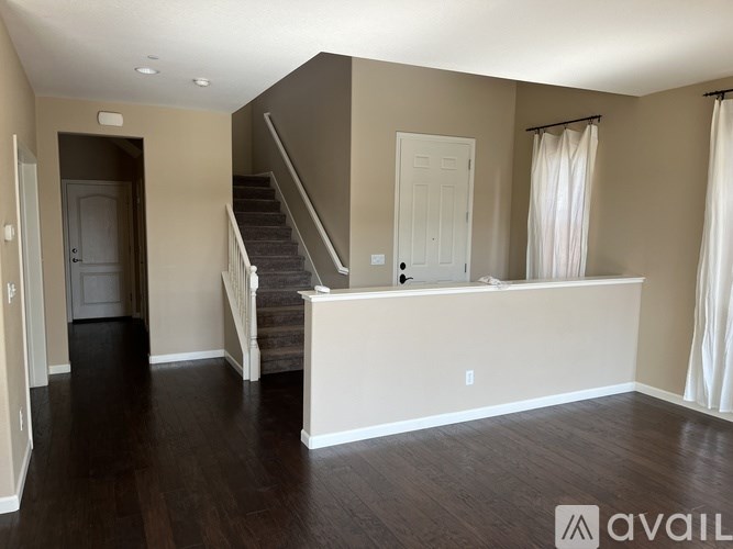 A spacious living room with a staircase leading to the upper level.