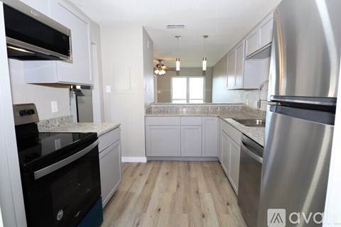 A kitchen with a black oven and a stainless steel refrigerator.