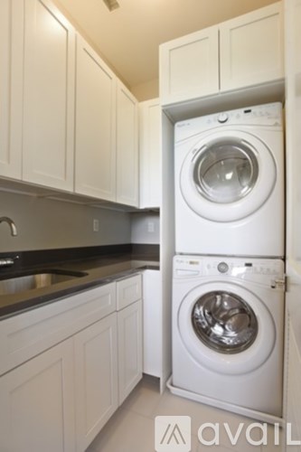 A white washing machine is in a cabinet in a kitchen.