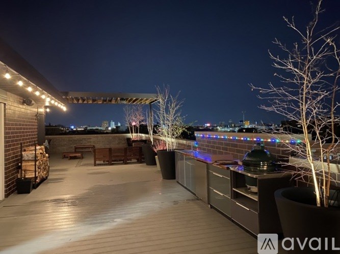 A balcony with lights and a view of the city at night.