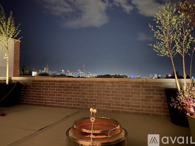 A balcony with a hot tub and a view of the city at night.