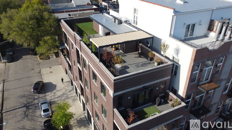 An aerial view of a multi-story building with a parking lot in front.