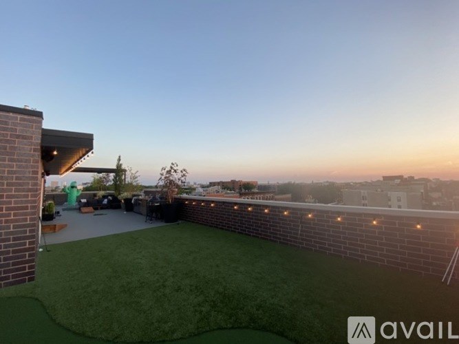 A rooftop patio with a brick wall and string lights.