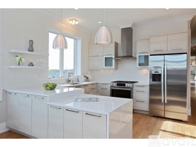A modern kitchen with white cabinets and stainless steel appliances.