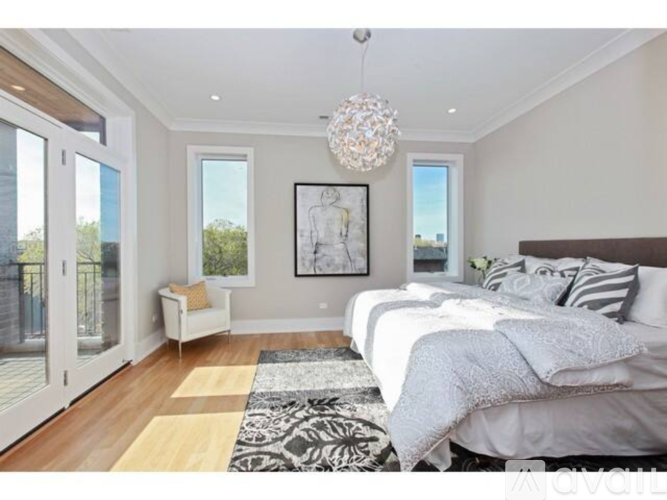 A bedroom with a large bed and a chandelier.
