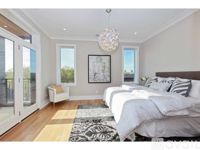 A bedroom with a large bed and a chandelier.