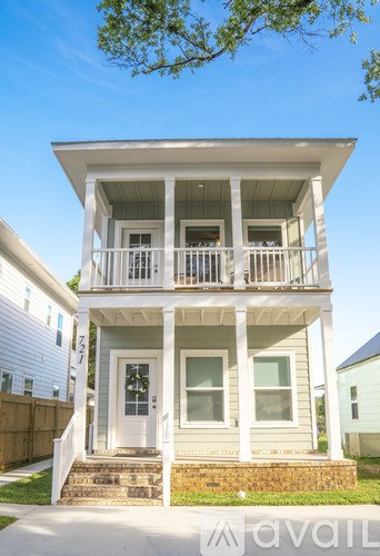 A two-story house with a balcony on the second floor.