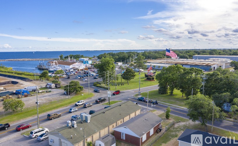 A busy street with cars and buildings with an American flag in the background.