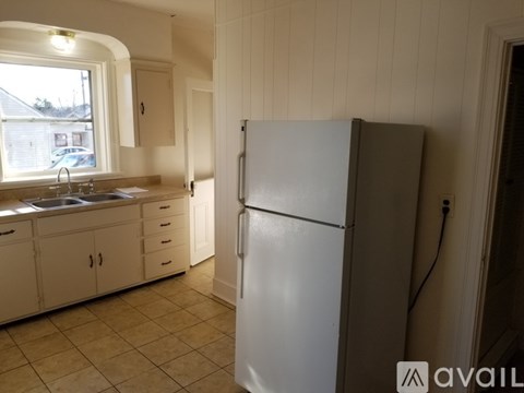 A kitchen with a white refrigerator and cabinets.