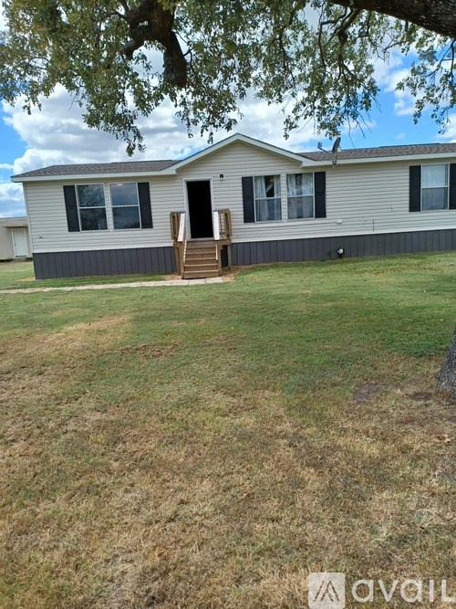 A mobile home with a brown lawn in front.