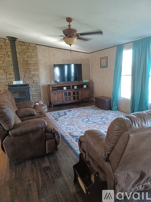 A living room with a wood stove and a flat screen TV.