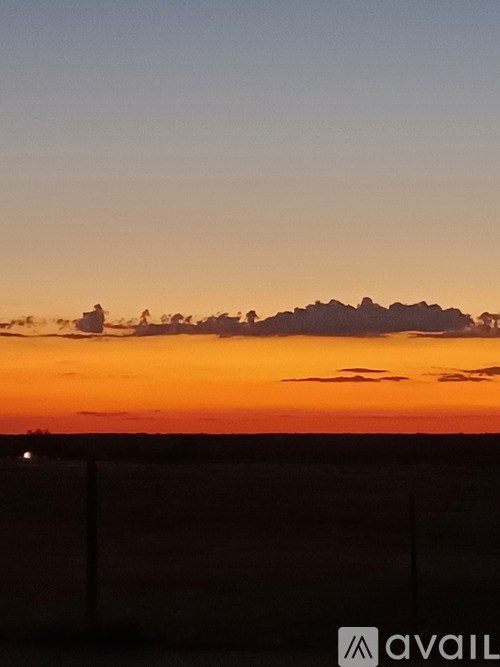A group of people are silhouetted against a sunset sky.