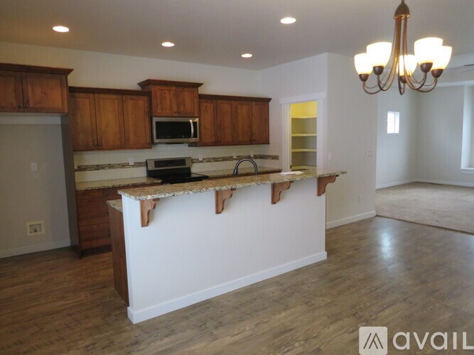 A kitchen with wooden cabinets and a white island.