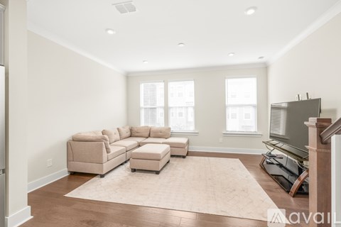 A living room with a beige sofa and ottoman.