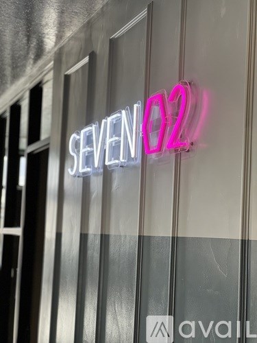 A neon sign that says "SEVEN 02" in pink and white.