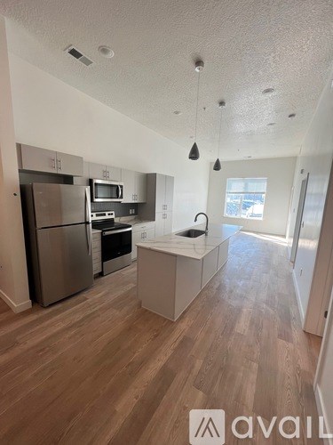 A kitchen with wooden floors and a refrigerator.