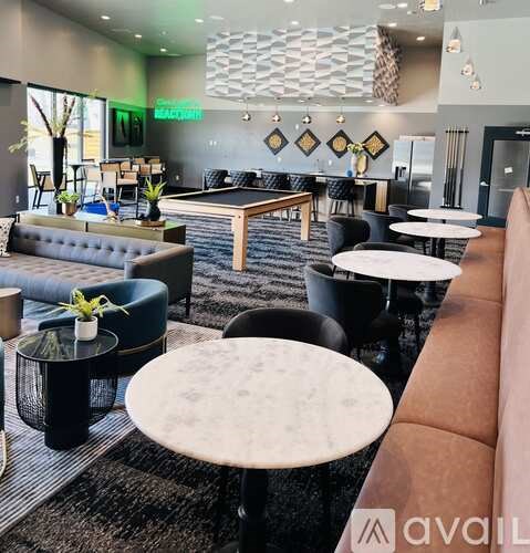 A modern lounge area with a pool table and comfortable seating.