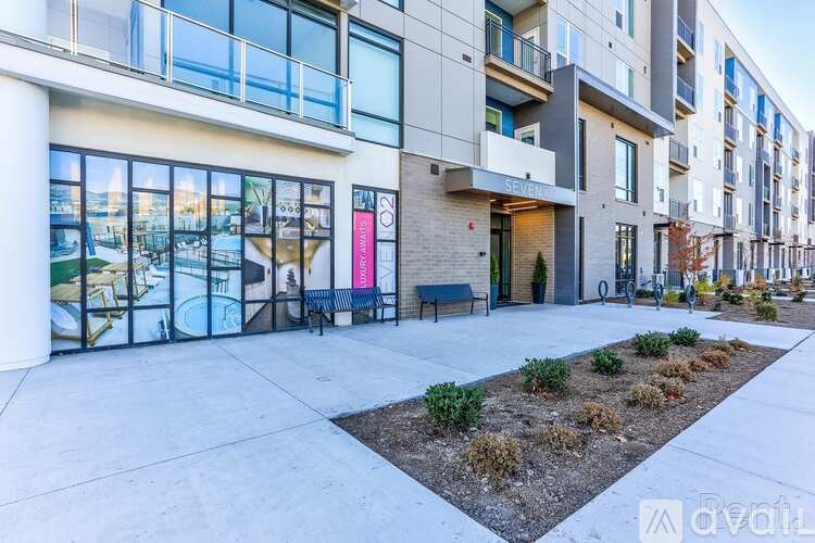 A modern apartment complex with a landscaped courtyard in front.