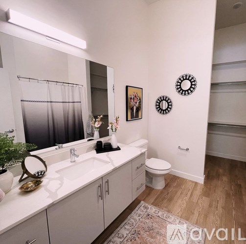 A bathroom with a white counter top and a white toilet.