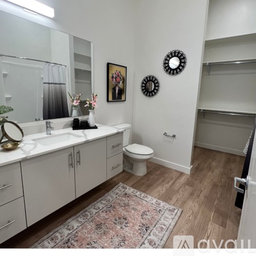 A bathroom with a toilet, sink, and mirror.