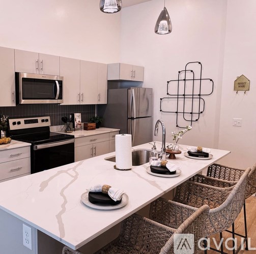 A kitchen with a table set for two with a white table cloth.