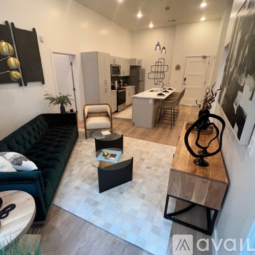 A modern living room with a black couch and a wooden coffee table.