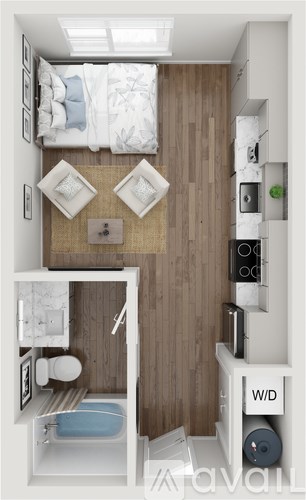 A small bedroom with a bed, a chair, a table, and a toilet.