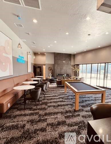 A room with a carpeted floor and a long table with chairs.