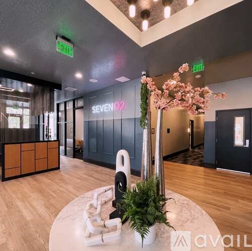 A reception area with a sign that says "Seven 02" and a plant in a vase.