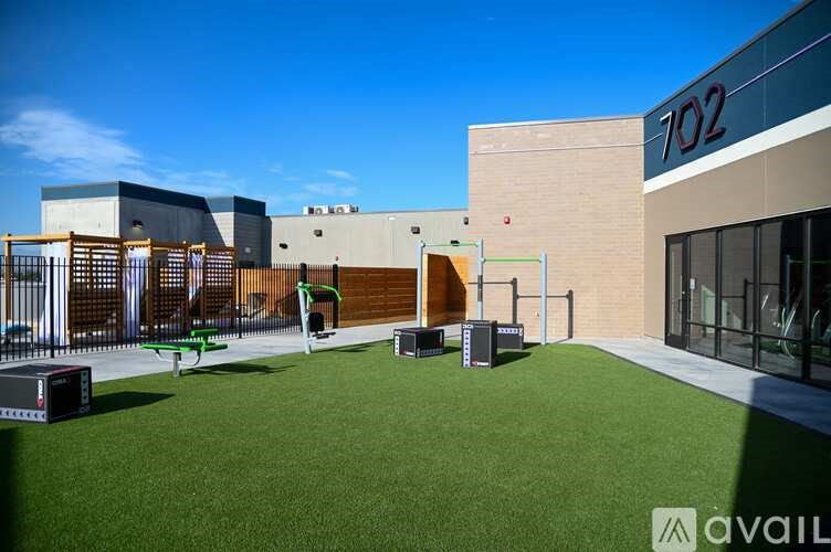 A playground area in front of a building with the number 702 on it.