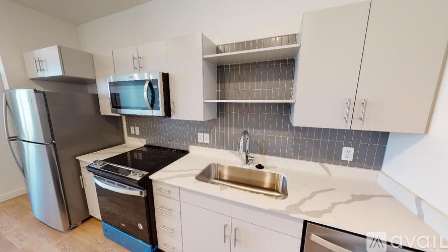 A kitchen with a stainless steel refrigerator, a microwave, a dishwasher, and a sink.