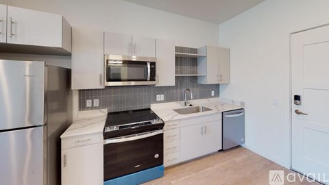 A kitchen with white cabinets and a stainless steel refrigerator.