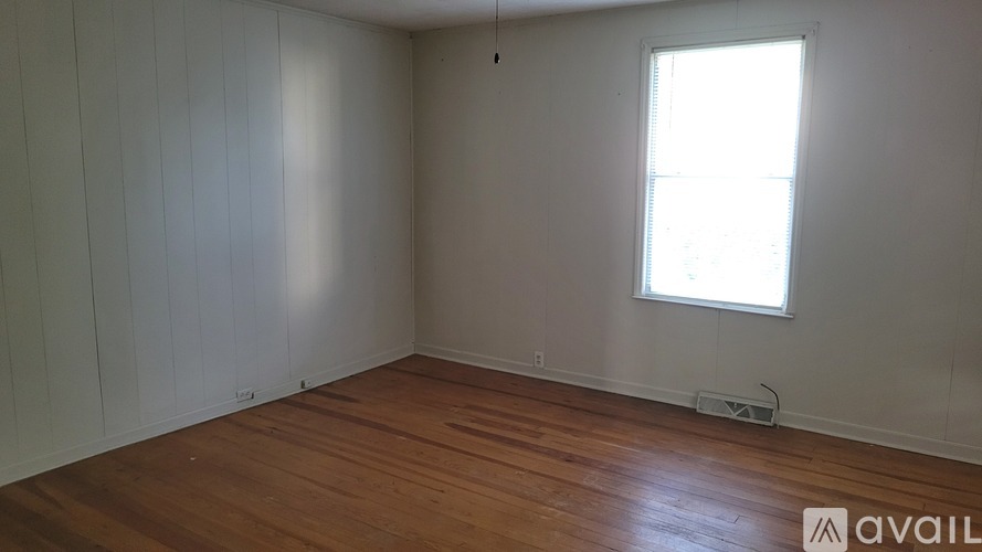 A room with wooden flooring and a window.