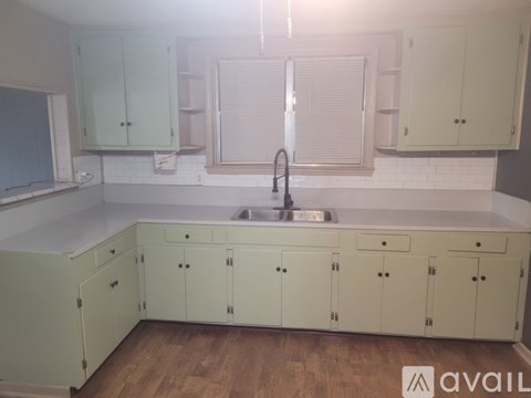 A kitchen with white cabinets and a sink.